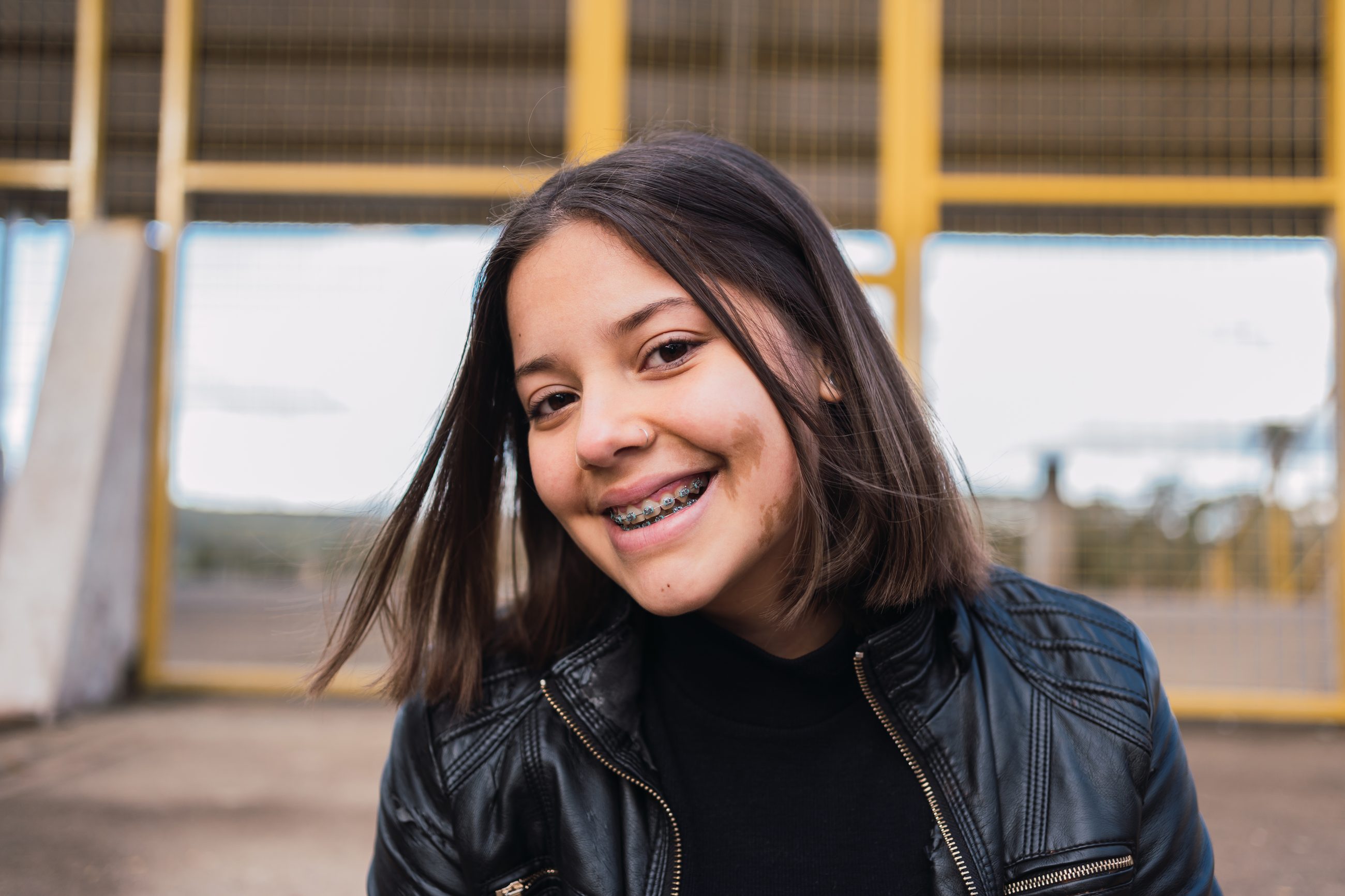 A smiling teenage girl with metal braces
