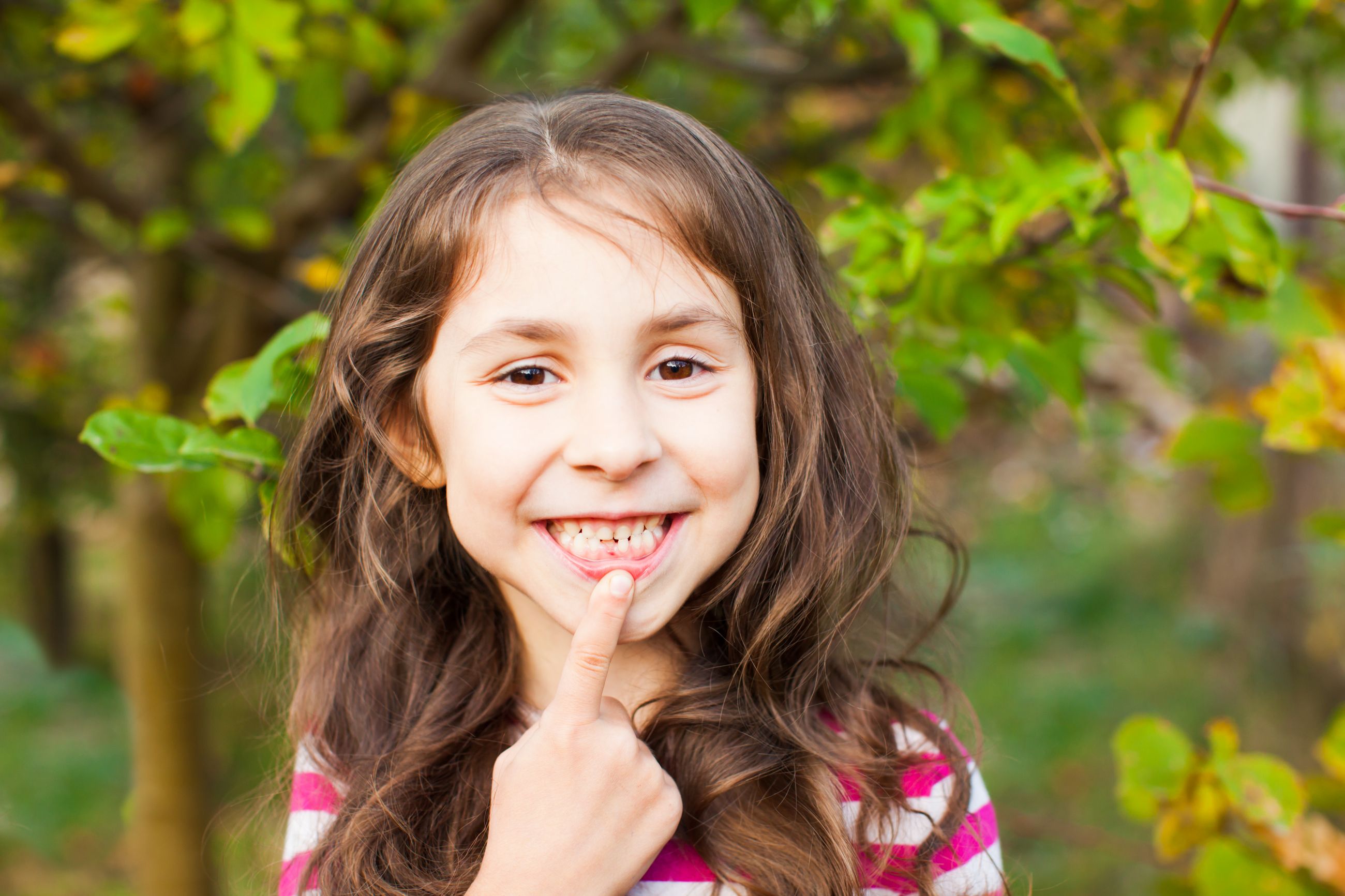 A smiling young girl outdoors in summer