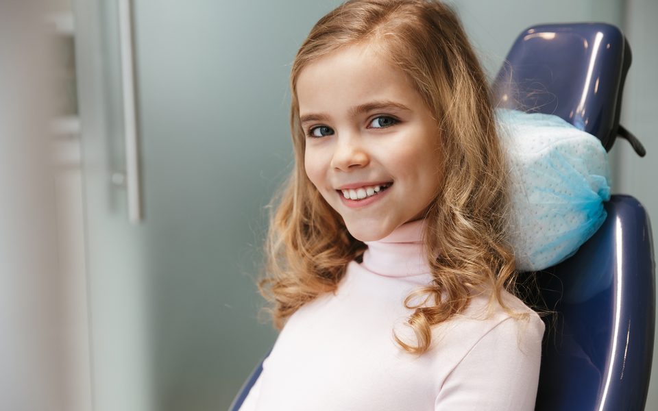 A smiling girl in an orthodontic chair