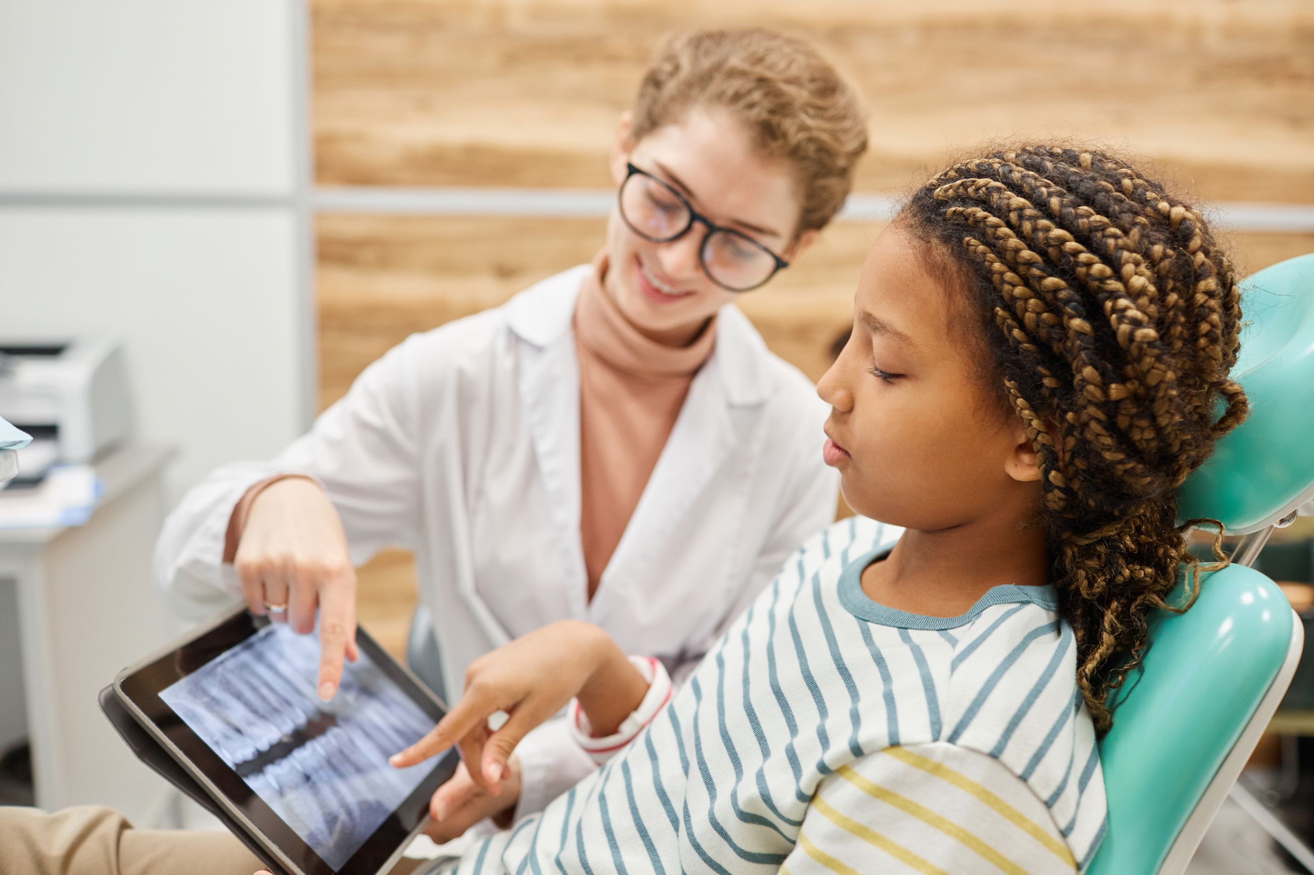 A team member showing a smiling girl her plan on a tablet